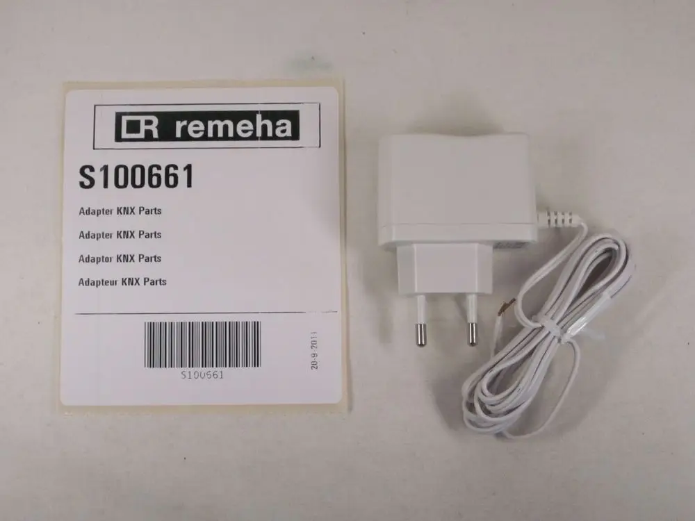 Stromadapter von Remeha mit zwei Stiften und Anschlusskabel. Verpackung mit der Artikelnummer S100661 und Informationen zu Adapter KNX Parts.